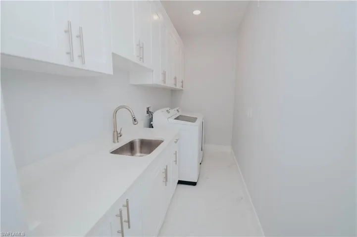 Laundry room featuring cabinets, independent washer and dryer, and sink