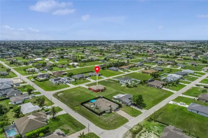 Aerial view of property and surrounding area featuring nearby suburban area