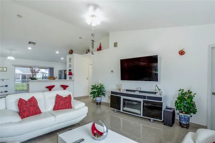 Living room featuring vaulted ceiling and recessed lighting