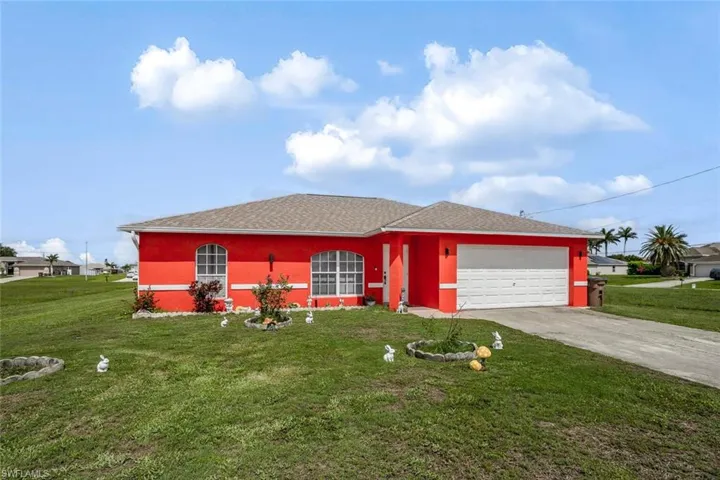 Ranch-style home featuring a front lawn, driveway, roof with shingles, and a garage