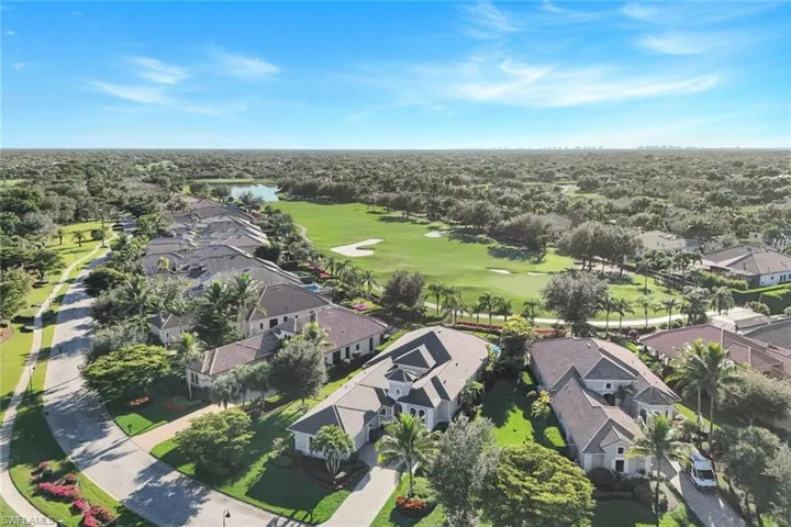 Aerial overview of property's location with nearby suburban area, a golf course, and a nearby body of water