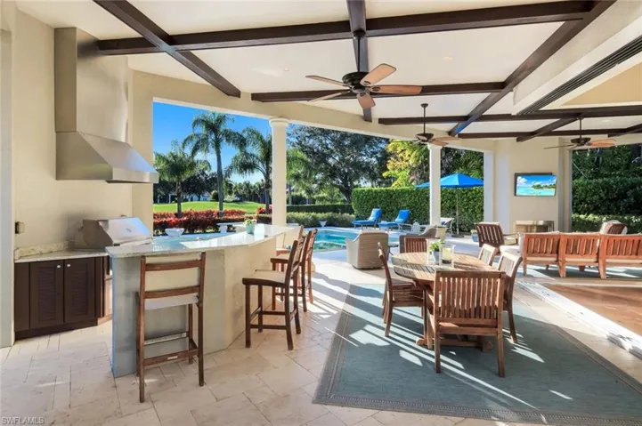 View of swimming pool featuring a patio area, a pool with connected hot tub, and an outdoor living space with a fire pit