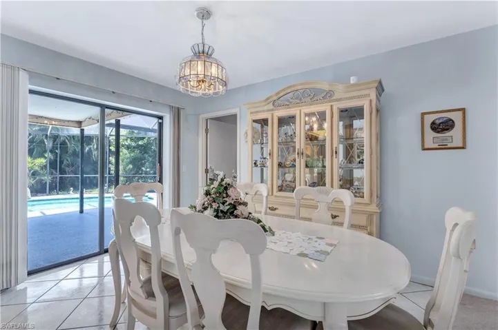 Tiled dining room featuring a chandelier