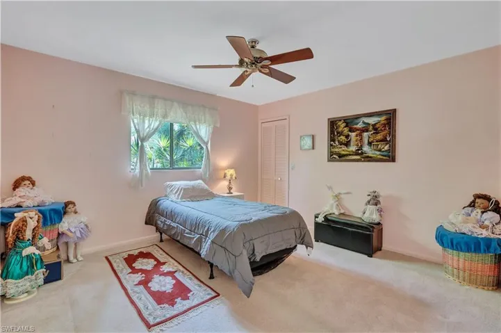 Carpeted bedroom featuring a closet and ceiling fan
