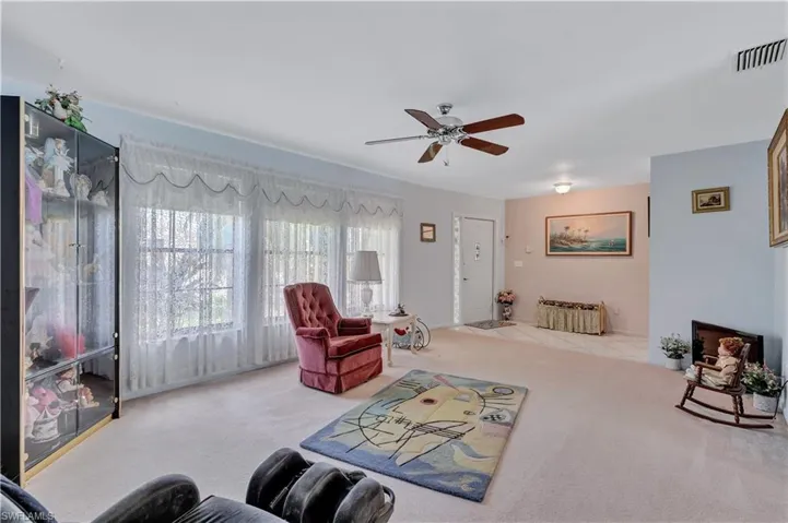 Carpeted living room featuring ceiling fan