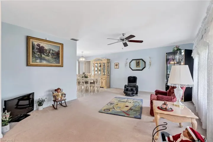 Carpeted living room featuring plenty of natural light and ceiling fan