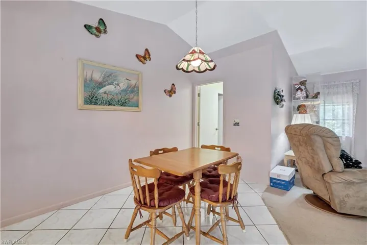 Dining room featuring vaulted ceiling and light tile patterned flooring