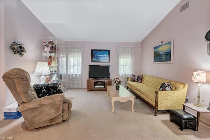 Carpeted living room featuring lofted ceiling