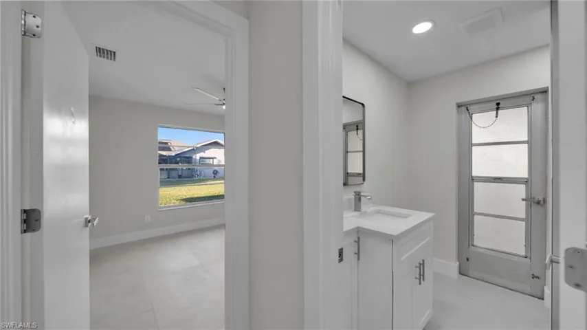Bathroom with vanity, a ceiling fan, and recessed lighting