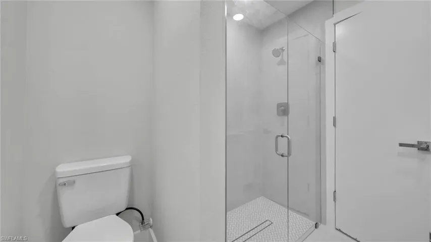 Full bath featuring toilet and a shower stall