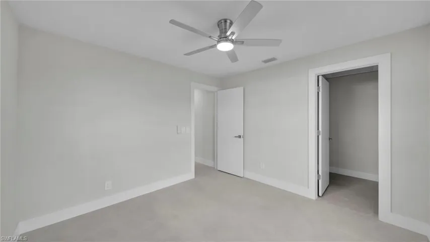 Unfurnished bedroom with a spacious closet and ceiling fan