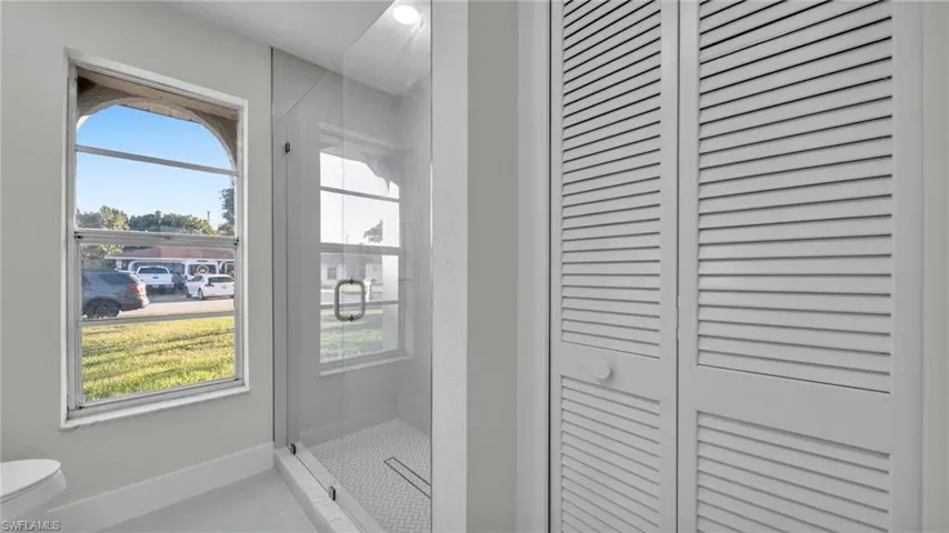Bathroom featuring a stall shower and a closet