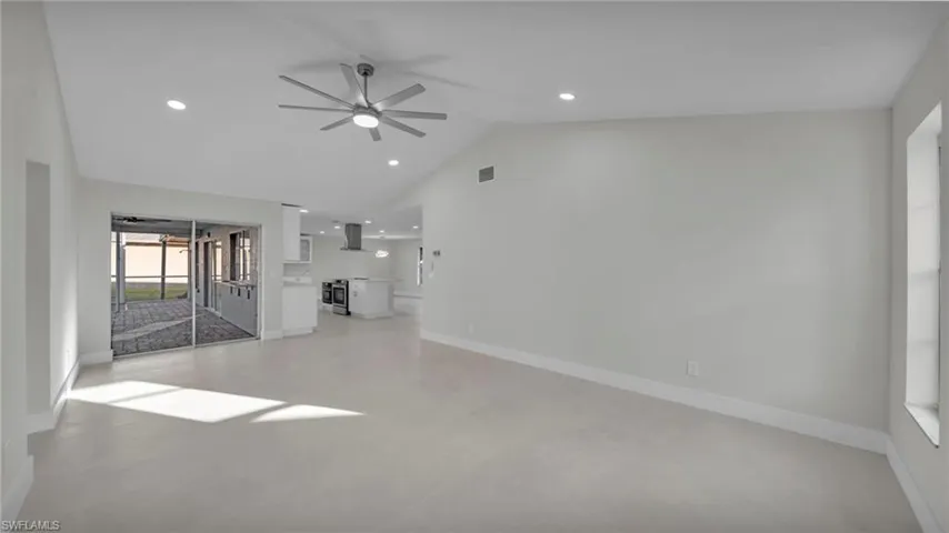 Unfurnished living room featuring a ceiling fan, recessed lighting, and lofted ceiling