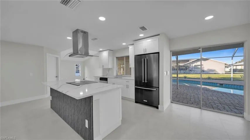Kitchen featuring black appliances, light stone countertops, white cabinetry, island exhaust hood, and a center island