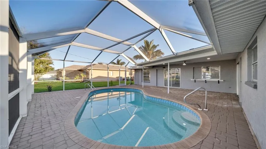 Outdoor pool with a patio, a sunroom, a lanai, and a yard