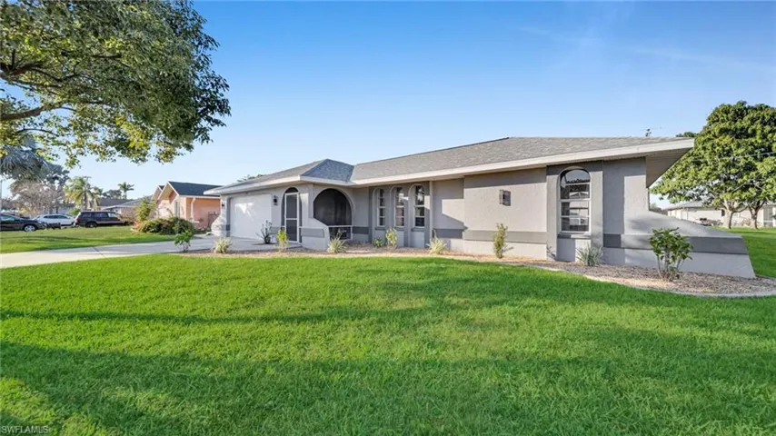 Ranch-style house with stucco siding, a front yard, concrete driveway, an attached garage, and roof with shingles