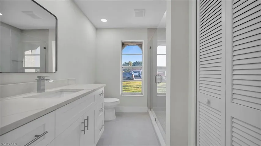 Bathroom with a closet, a shower stall, and vanity