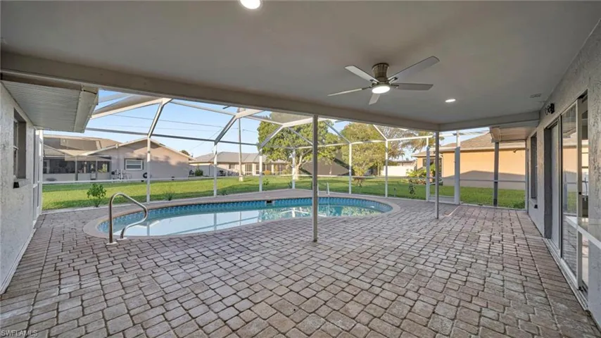 Swimming pool featuring a patio, a sunroom, and glass enclosure