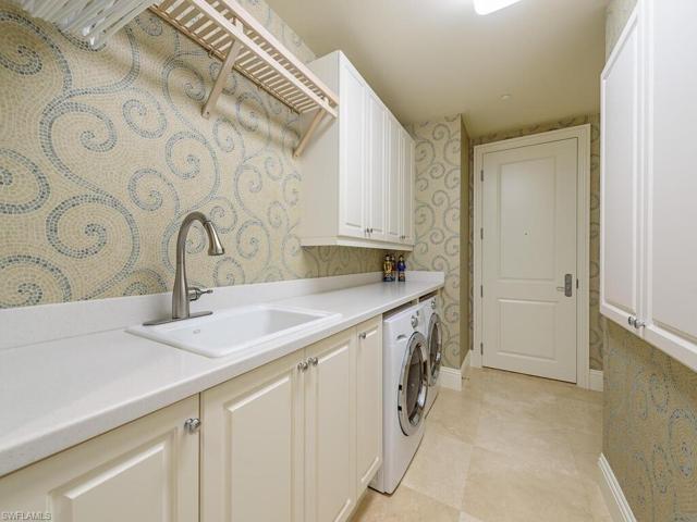This large laundry with sink has plenty of counter space and storage areas.