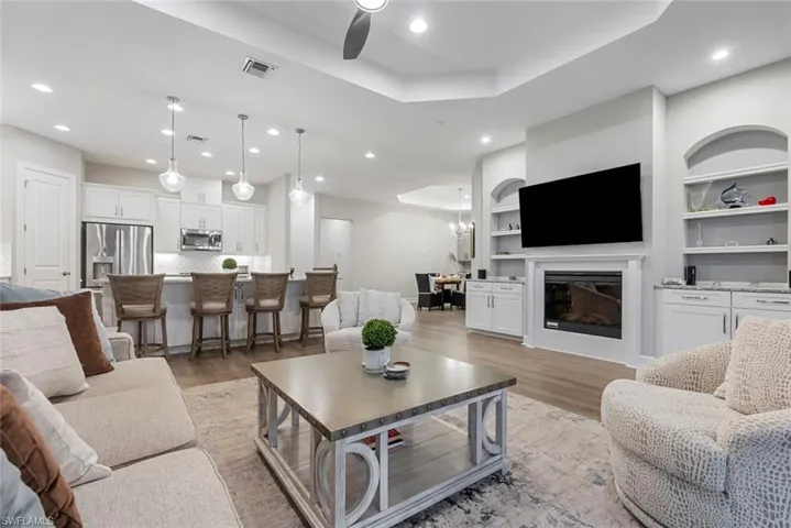 Living room featuring light wood-type flooring, an inviting chandelier, and a wealth of natural light