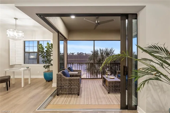 Sunroom featuring ceiling fan with notable chandelier