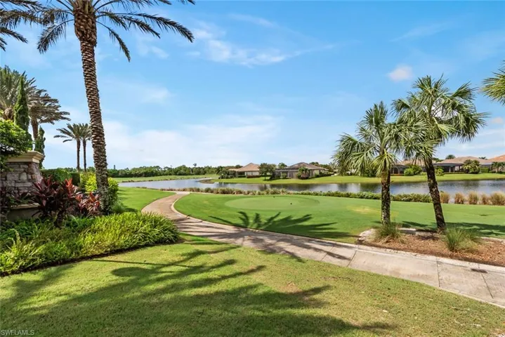 View of property's community featuring a lawn and a water view