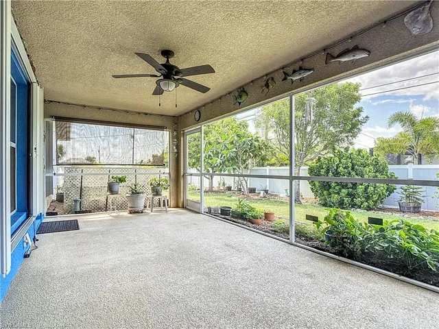 Screened lanai overlooking back yard with tropical plantings