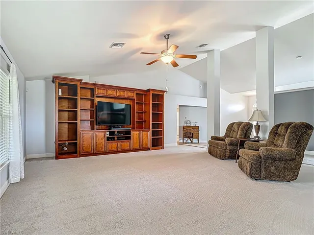 The newly carpeted living room includes the large entertainment unit.