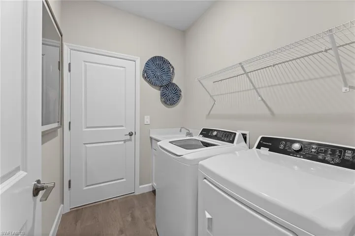 Laundry area with dark wood-style floors and washing machine and clothes dryer
