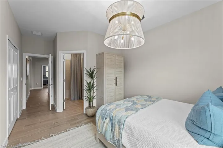 Bedroom with wood finish floors and a chandelier