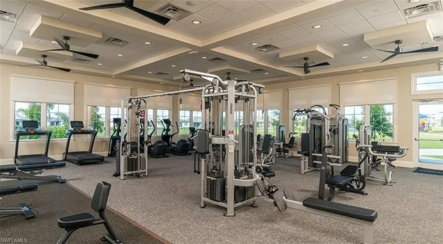 Workout area with a ceiling fan, recessed lighting, and high coffered ceiling