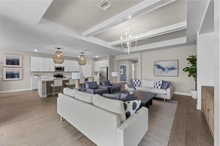 Living area featuring wood tiled floors, a chandelier, and beamed ceiling