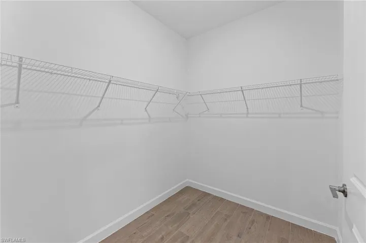 Walk in closet with light wood-type flooring