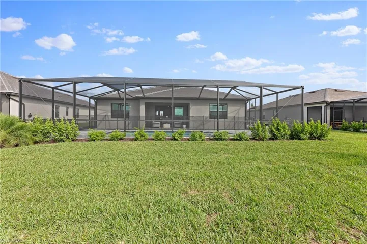 Back of property featuring a lanai, a sunroom, a yard, and a pool