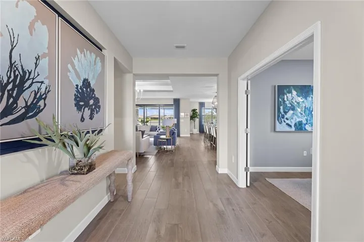 Hall with dark wood-style flooring and baseboards