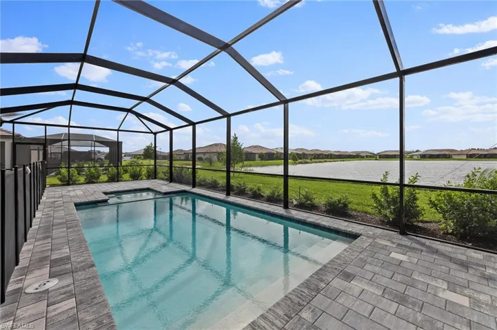 Swimming pool featuring a residential view, a sunroom, a lanai, and a water view
