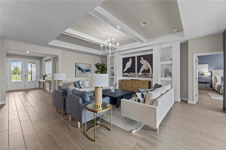Living room with wood finish floors, french doors, built in features, suspended lighting, and beamed ceiling