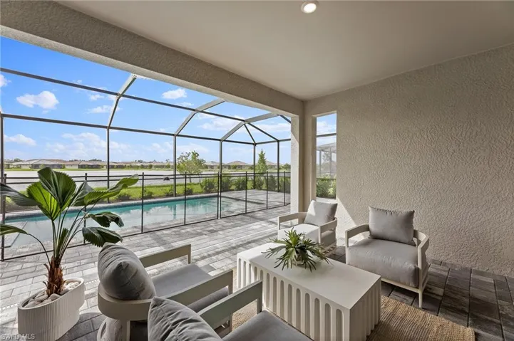 View of patio / terrace featuring a sunroom, outdoor seating, an outdoor pool, glass enclosure, and a residential view