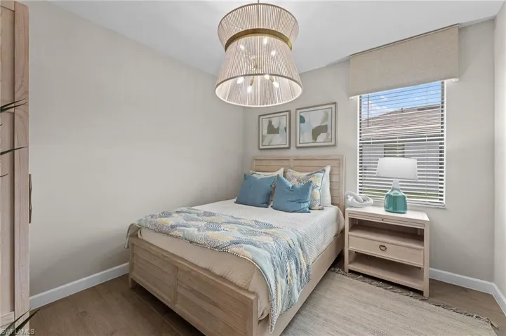 Bedroom featuring a chandelier and light wood finished floors