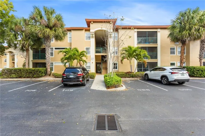 View of apartment building / complex with uncovered parking