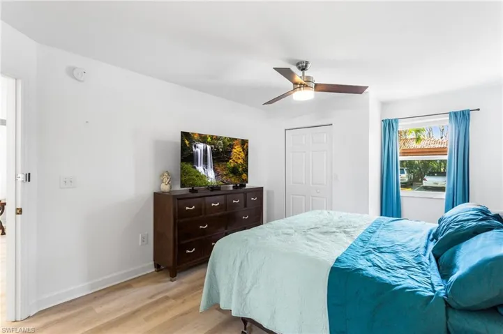 Bedroom featuring light wood finished floors, a closet, and a ceiling fan
