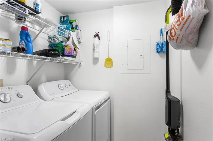 Laundry area featuring electric panel and separate washer and dryer