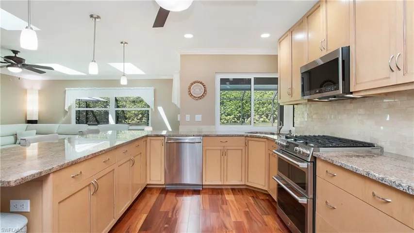 Kitchen with a double sink, stainless steel appliances and tasteful backsplash