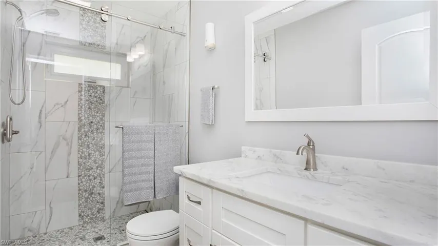 Guest bathroom renovated tile shower and vanity with Quartz countertop