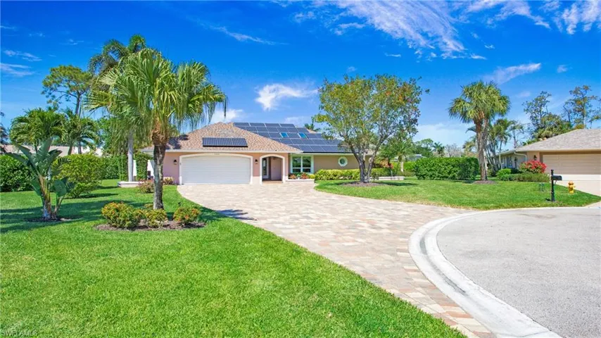 View of front of house featuring solar panels, 2 car garage, paver stone driveway
