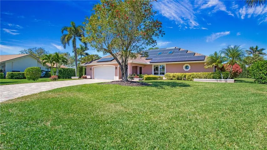 View of front facade featuring a 2 car garage, solar panels and Paver Stone driveway