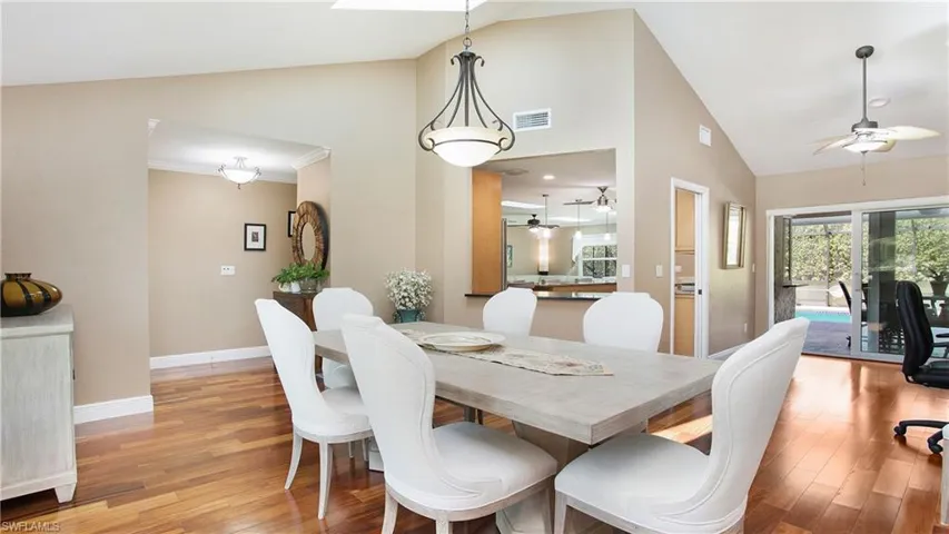Dining area featuring high vaulted ceiling, wood flooring and pass through to Kitchen for serving meals