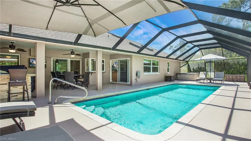 Outdoor pool with a hot tub, a patio, ceiling fan, a lanai, and outdoor dining area
