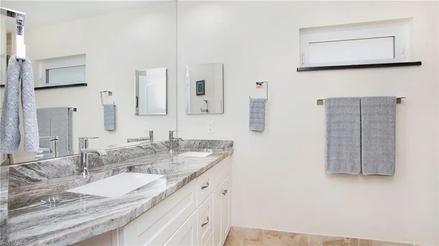 Primary bathroom featuring double vanity, 2 sinks and awning window