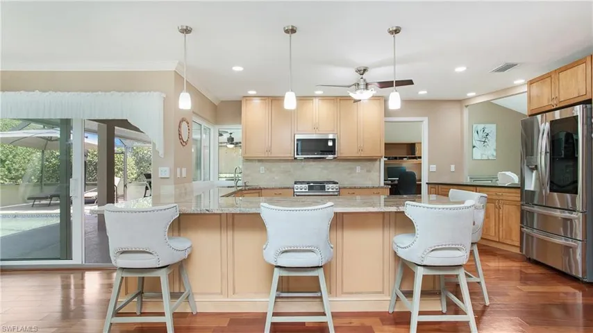 Kitchen featuring appliances with stainless steel finishes and a large peninsula for preparing meals or dining.